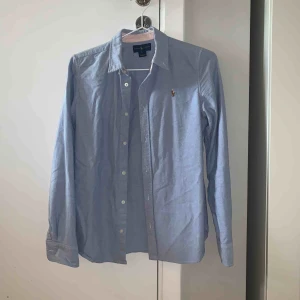  - Blå skjorta från Ralph Lauren. Storlek 16 i barn men motsvara en XS. Nypris ca. 700kr