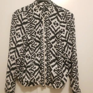  - Kofta/tröja i snyggt mönster. Guldig dragkedja. Använd vid fåtal tillfällen . 100% polyester 