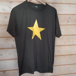 T-shirt med gul stjärna strl L - Oversized tisha, fint skick endast använd fåtal gånger. Lite slit på trycket, inget märkvärdigt.