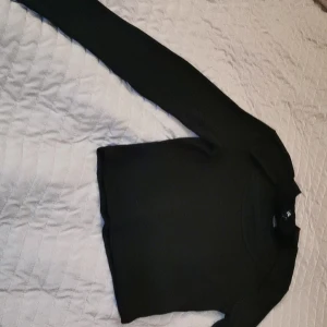 Sexig svart topp  - En ribbad svart tajt topp men öppning vid bröstet. Aldrig använd, nytt skick 