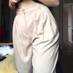 Byxor från Weekday! - Säljer mina begiea kostymbyxor från Weekday då de inte används. Skicket är bra med lite noppror på sidan. De är i en croppad ballon-aktig modell. Supersnygga och jättesköna! Priset kan diskuteras :-)