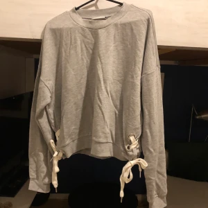 Tröja  - Grå tröja som är väldigt mysig och bara använd ett få tal gånger. Snörning på sidorna. Du står för frakten. 