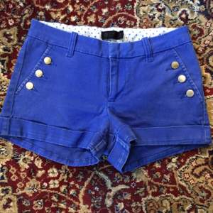 Blå shorts från Gina Tricot. Storlek 34. Guldiga knappar. 