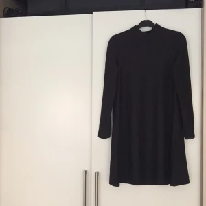  - Svart enkel, smått klockad klänning med minipolo. Supersnygg ! FRI FRAKT !
