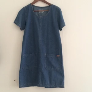  - Supersöt jeansklänning i kort modell. Två fickor fram. Köpt vintage. Frakt tillkommer eller upphämtas i centrala Gbg.