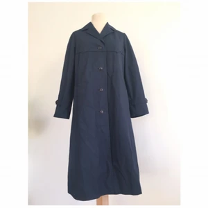 - Mörkblå trenchcoat i klassiskt snitt.  Märke: Piiron (Vintage från Finland) Storlek: 36 Skick: Mycket gott. Aldrig använd.  Pris: 400:- eller bud.  Frakt: Betalas av köparen.
