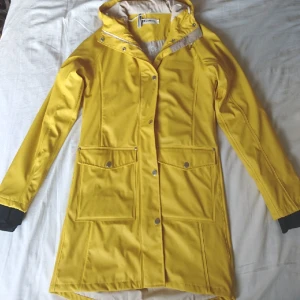  - Regnjacka från Tretorn, modell Erna. Tunt foder samt ärmuddar som ger ytterligare regnskydd. I perfekt skick. Länk till produkt: http://se.tretorn.com/tretorn/Regnklader/ErnaRaincoat/Gul