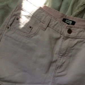  - Jeansshorts i ljus pastelrosa. Avklippt sliten kant. Passar en S/M.