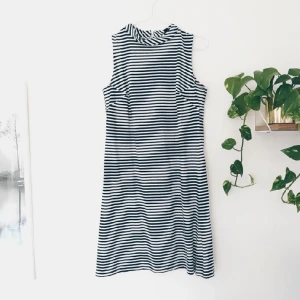  - Randig klänning med hög hals. Dragkedja i ryggen, jag har sytt in den vid bysten men det kan lätt sprättas upp. Använd enstaka gånger. Märkt som en storlek 2 men passar mig som har 38.