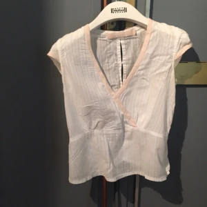  - Söt topp från svenska märket Plus. Den är djupt V-ringad och har vacker knäppning i ryggen. Dragkedja sitter i sidan! 