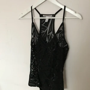  - svart body i spets från nly trend. smala axelband och brottarrygg, knäppning i grenen. storlek small men skulle nog även passa någon med storlek medium. fint skick! kom med bud, paketpriser vid köp av flera plagg. köparen betalar frakt.