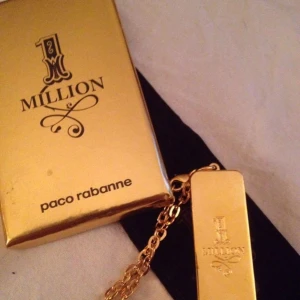  - Paco Rabanne 1 million "guldtacka" ( inte guld !! ) smycke till nyckelknippa eller väska .. Ngt ärgad men en putsning borde fixa det . berlocken är ganska tung och 5,2 cm lång , berlock + kedja är 13 cm