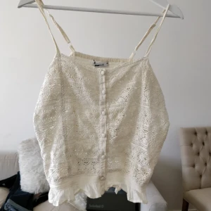  - Ljus, broderad kort topp från Gina Tricot. Strl 40 men jag som har storlek 36-38 har använt den, den är luftig så passar många kroppstyper. Fina detaljer, justerbara axelband. Skriv vid frågor! Frakt: 20 kronor 