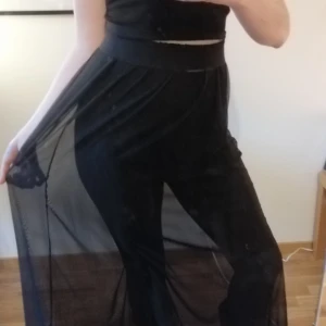 Mesh kjol maxi kjol - Maxikjol i svart mesh-material. Brukade ha en underkjol men klippte av den då den var för kort för mig. Kjolen är genomskinlig, men kan användas med tex en annan kort kjol/klänning under eller ett par coola leggings. Midjan är ett brett resorb and, det är silvrigt, men man kan vika ner det dom jag gjort på bilderna så blir midjeresoren svart istället. Frakt tillkommer 