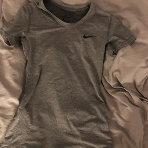 Träningstopp Nike - Säljer denna snygga träningstoppen från Nike i storlek XS. Toppen är tajt och formar sig efter kroppen. Aldrig använd. Skriv för fler bilder! 🤩
