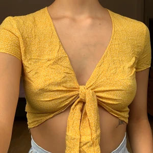 Gul topp - 3 för 100kr på allt som kostar 45kr! Gul topp med knytning från Bershka, använt men fint skick! +44kr frakt(tänk på att fraktkostnaden kan ändras)