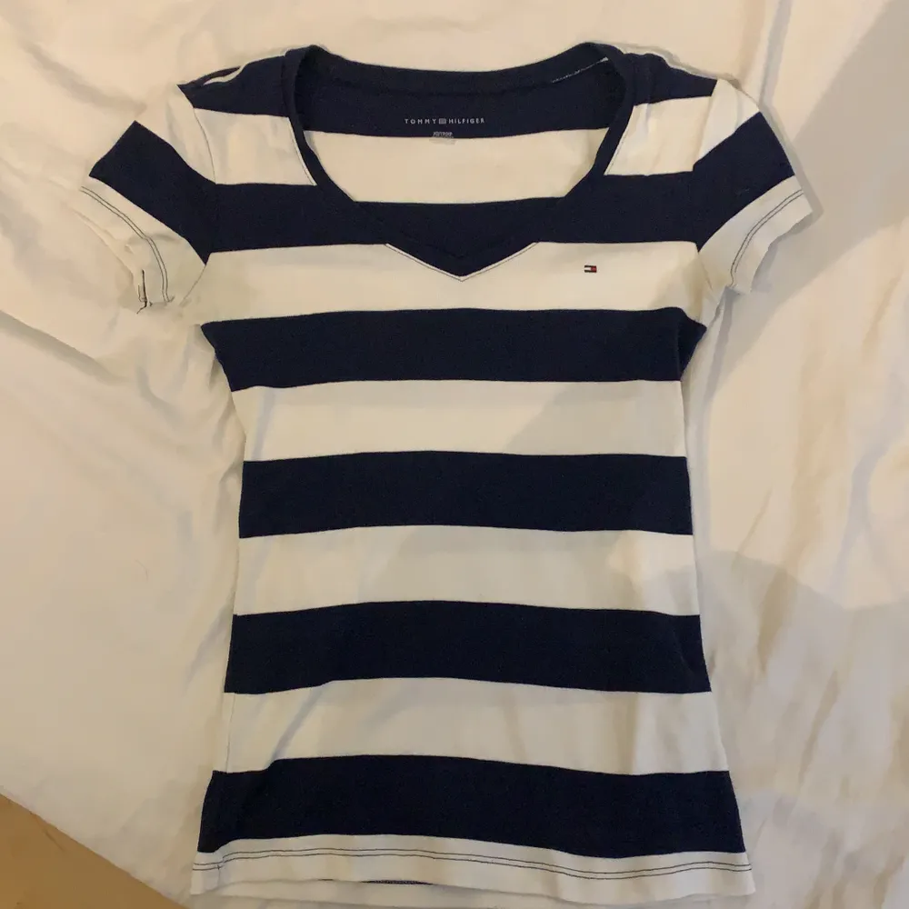En vit och marinblå t-shitt från Tommy Hilfiger. Köpt i USA och är XS. Väldigt stretchig så passar mig som vanligtvis är en S/M. T-shirts.