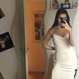 Beige/ljusrosa klänning från nelly - Medellång klänning i storlek S. Slits och knytbara axelband med justerbar storlek. Använd en gång. Frakt på 40 kr tillkommer. 