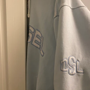Babyblå Hoodie - Ball, babyblå oversized hoodie från Diesel. Storlek L, har knappt använts och därmed säljs. Köparen står för eventuell frakt, kan gå ner i pris💘