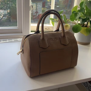 En jättefin aldirg använd furla väska i läder  - En ljus brun väska från furla aldrig använd. Nypris 3200 kr