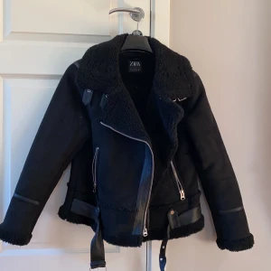 Jacka från zara strl L - En fodrad svart jacka i mocka-effekt, justerbara spännen i kragen samt i nederkanten, knäppning fram med omlott och dragkedja. Strl L men jag skulle säga att den är ganska liten i storleken, den är i bra skick då den inte har kommit till användning hos mig. Pris: 400kr + frakt 🥰 (ordinarie pris: 859kr)