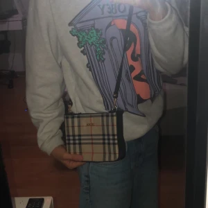 Väska - En gullig liten sidoväska med burberry inspo. Knappt använd dock fanns de ett handtag som klippt bort men syns knappt (Kan skicka bild) köparen står för frakt 
