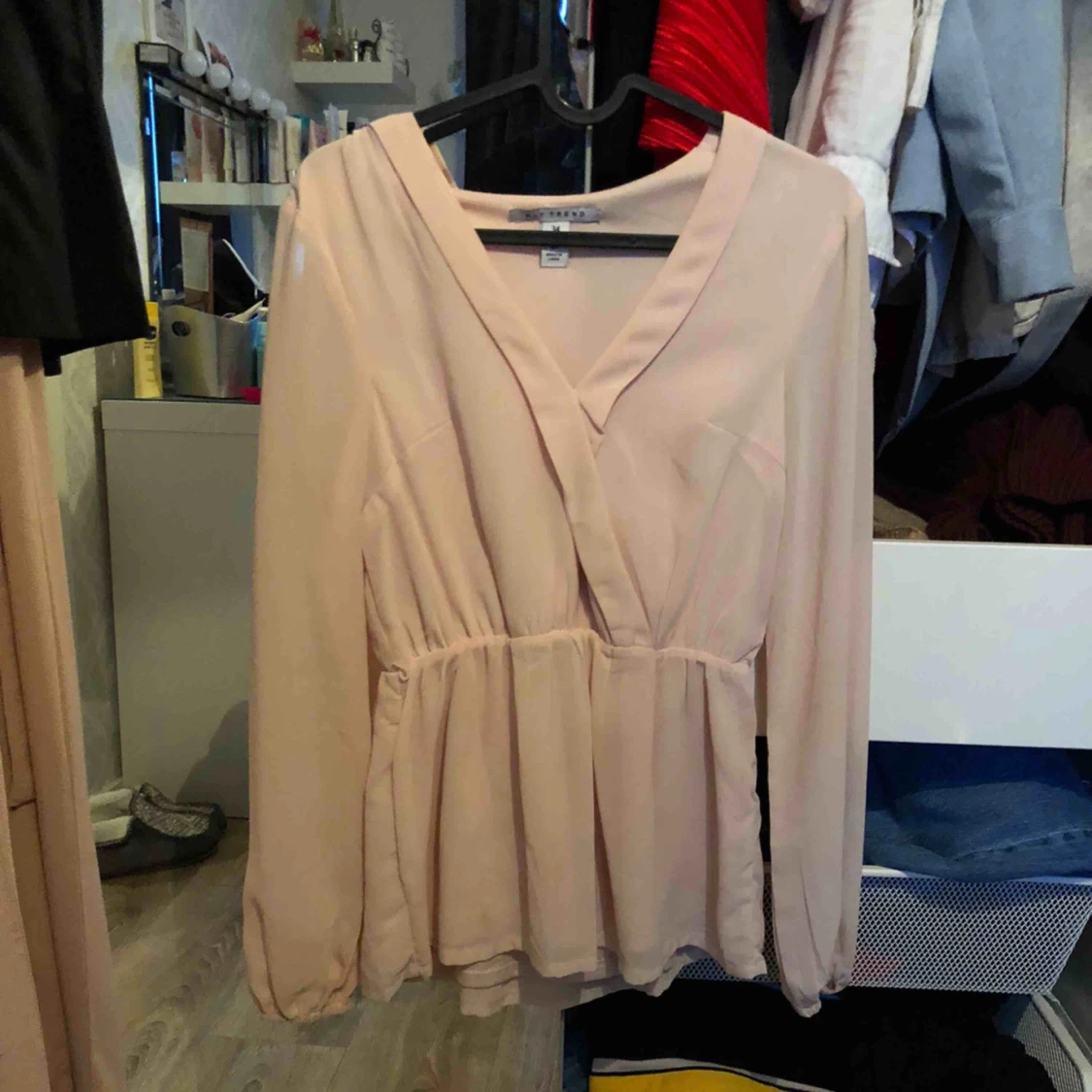 Ljusbeige blus med knytband runt midjan 