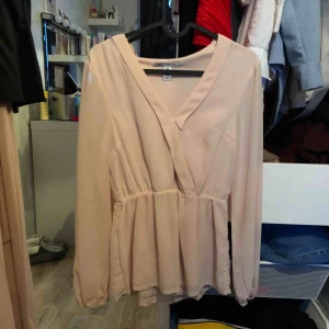 Ljusbeige blus med knytband runt midjan  - Ljusbeige blus från Nelly. Tillkommer band runt midjan! Storlek XS. 