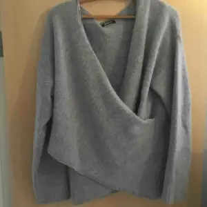En grå stickad omlott tröja, använd ett fåtal gånger