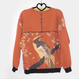 - En secondhand pärla. Unik orange kofta med blommor och fågel som motiv. Skick: secondhand, defekt fri.