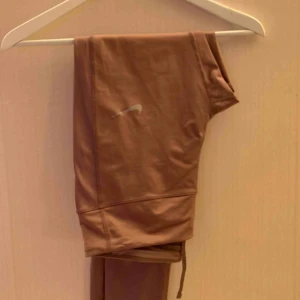  - Mörkrosa träningstights från Nike med snörning i midjan. Tightsen är högmidjade och har ficka på sidan samt bak som båda är stora nog för att hålla en iPhone 7.    Jag kan mötas i Borås, eventuellt Göteborg. Annars står köparen för frakten. 