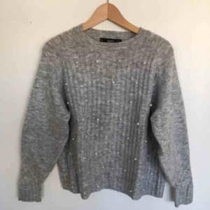  - Grå stickad tröja med pärlor framtill 