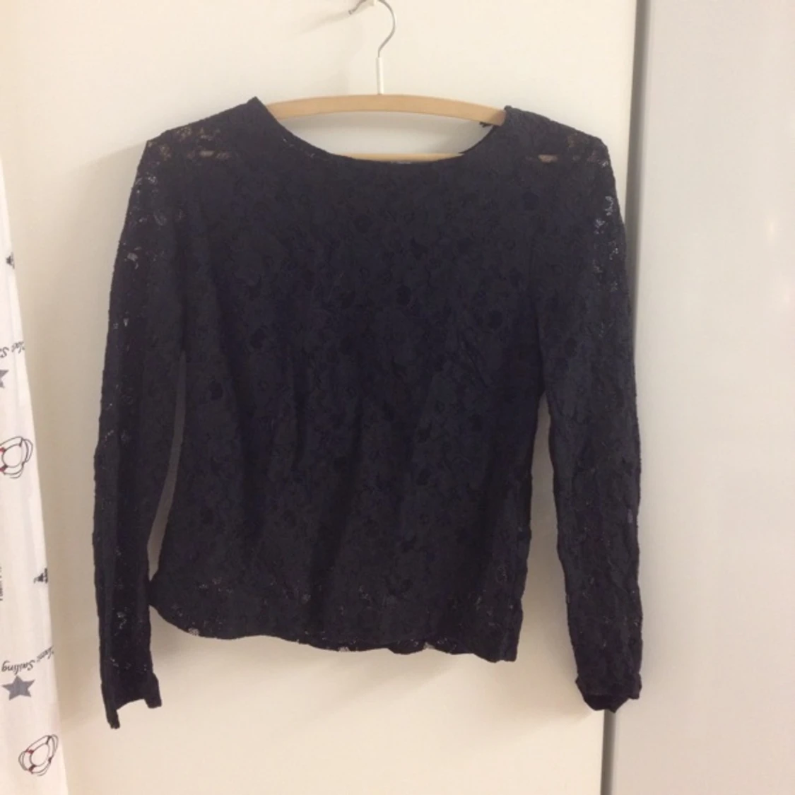 Svart spetströja med fina knappar i ryggen. Passar en str 34/36