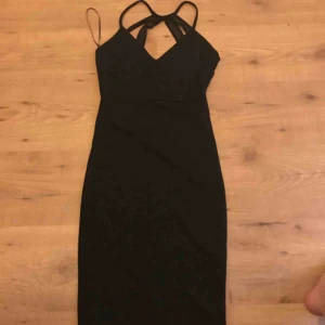  - Svart klänning med band i ryggen, aldrig använd pga fel stl! Kvar lappen