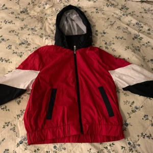 Hollister jacka - Tunn jacka från Hollister. Röd, blå och vit med luva. Storlek: Medium