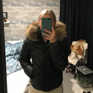 Dunjacka med päls - Varm och skön dunjacka med pälskrage från Chelsea. Storlek 40 men skulle säga att den är stor i storlek då den passar mig som vanligtvis är en S. Använd fåtal gånger så den är i fint skick. Köptes för 2000.