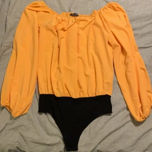 Snygg, gul body! - Jättesnygg body i off-shouldermodell från Nelly i storlek S! Endast använd en gång så den är som ny! 🌼