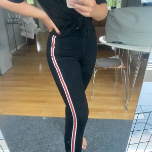 Svarta jeans med rödvita revärer - Svarta jeans från zara med revärer. Stretchiga och sitter väldigt snygg och ger bra form. Priset ligger på 150kr och frakten är inkluderad i priset🦋