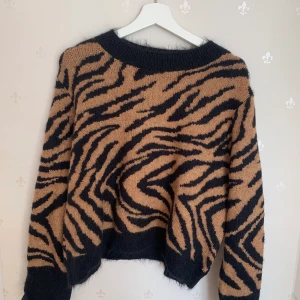 Stickad tröja  - En fin stickadtröja med leopard mönser                            Använd fåtal gånger alltså i bra skick.                                       Köparen står även för frakt.