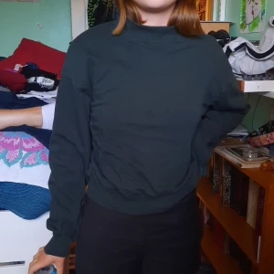 Tjock tröja från weekday - Mörkgrön collegetröja från fredag! Supersör o skön🥰2,5 monsterburkar hög och lika bred över magen, visad på en S