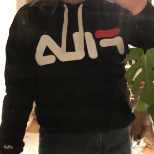 FILA hoodie - En jätteskön svart fila hoodie i lite större modell. Den är i gott skick utan fläckar samt slitningar. Den är snygg till både vardags men också att klä upp.  Kan mötas i Göteborg annars står köparen för frakten😊