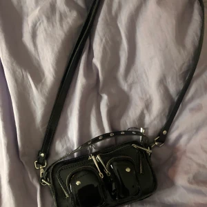 Mini NuNoo väska i lack!! - Nunoo mini bag i lack, orginal pris runt 1300;-, inte använd så mycket väldigt fint skick, får även med en kedja (första bilden)  Pris kan diskuteras vid snabb affär!