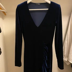 Klänning från fashion nova - En mörkblå klänning i sammet. V ringad och har en slit vid benet. Oanvänd