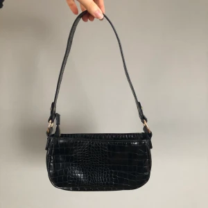 90-tals axelremsväska ASOS - Svart krokodilmönstrad väska från ASOS. Knappt använd, superbra skick!