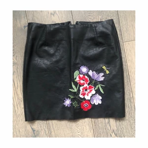 Kjol skinnimitation  - Svart kjol med blommönster i skinnimitation, storlek XS (34) 💗