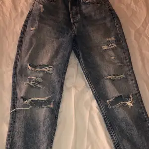 Blåa mom jeans med hål från H&m i storlek 34. Säljes för 160 kr, gratis frakt