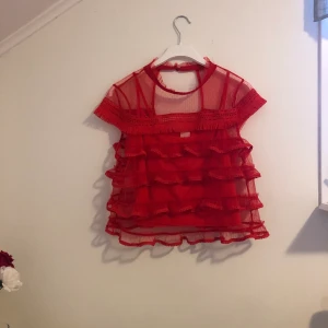 Röd topp - En röd topp från river island! Den är i storlek 14 (eur-40) men är i deras petite kollektion så skulle säga att den är liten i storleken.