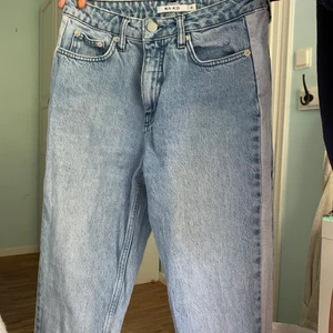 Mom jeans från NAKD - Supersnygga jeans från NAKD med ljusa revärer på sidorna. Är i bra skick, men har tyvärr blivit för små för mig. Storlek 36 men passar även 34. Nypris 400kr. Köparen står för frakt. 