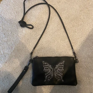 Axelbands väska  - Superfin svart axelbandsväska i svart läderimitation med strass fjäril🦋 använd 2-3 gånger så den är som ny! 