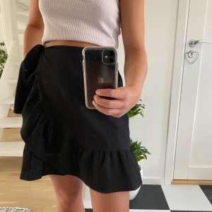 Kjol med volanger 🧚🏼 - En svart kjol från Vero Moda i storlek S💕, kjolen har band så att man kan knyta en rosett och har volanger. Kjolen är använd en gång. Den som köper står för frakten💘. 